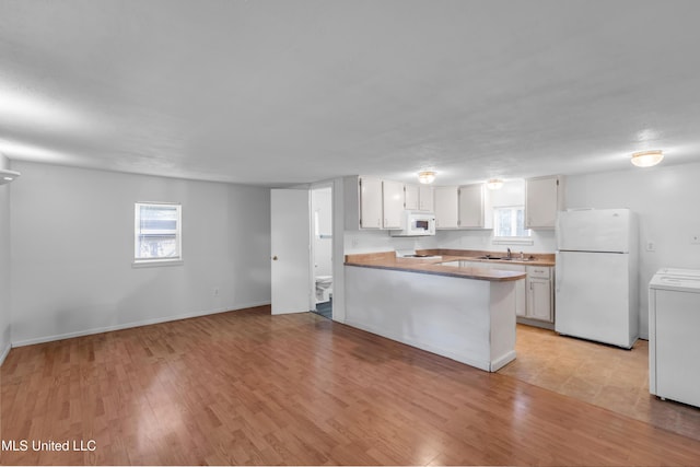 310 John Ave, Pascagoula, MS 39567 - kitchen with white appliances, a sink, plenty of natural light, and a peninsula