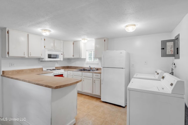 310 John Ave, Pascagoula, MS 39567 - kitchen featuring white appliances, washing machine and clothes dryer, a sink, a peninsula, and a textured ceiling