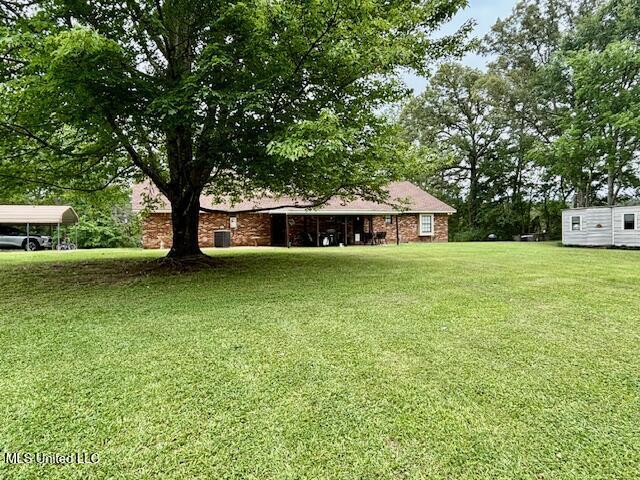 149 Martin Cir, Mendenhall, MS 39114 - view of green lawn with a detached carport