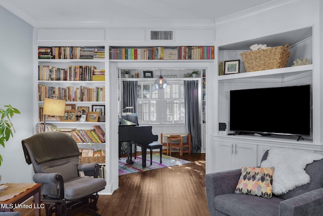 sitting room featuring ornamental molding, dark hardwood / wood-style flooring, and built in features