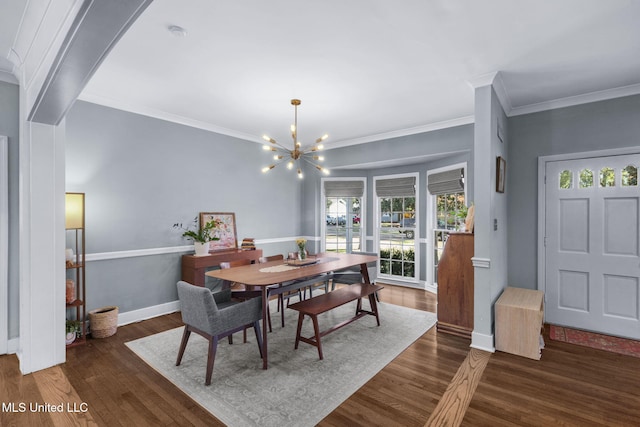 dining space with crown molding, dark wood-type flooring, and a notable chandelier