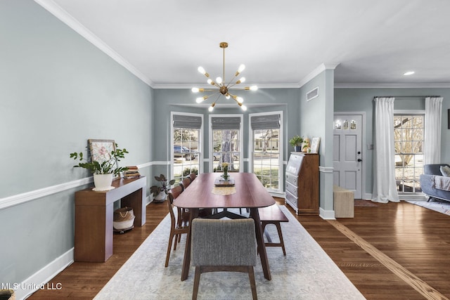 dining room featuring ornamental molding, an inviting chandelier, and dark hardwood / wood-style flooring