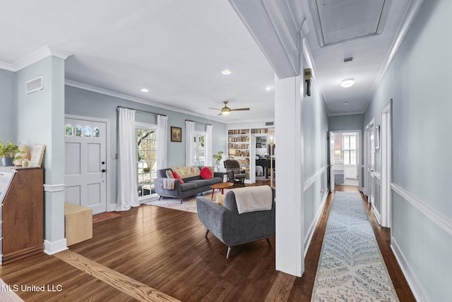 living room featuring ornamental molding, hardwood / wood-style floors, ceiling fan, and built in shelves