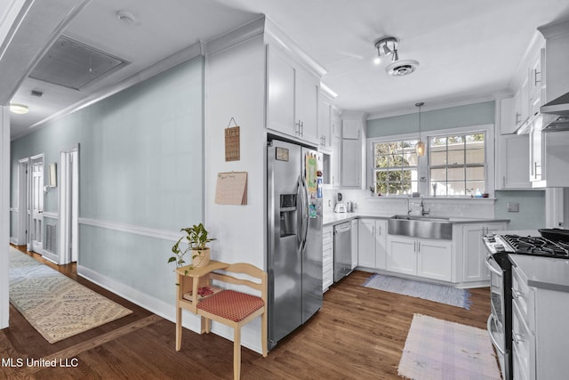 kitchen featuring dark wood-type flooring, sink, white cabinetry, ornamental molding, and stainless steel appliances