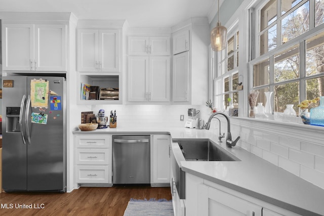 kitchen with white cabinetry, backsplash, pendant lighting, and stainless steel appliances