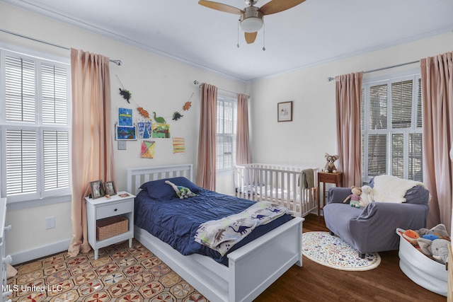 bedroom with multiple windows, crown molding, hardwood / wood-style floors, and ceiling fan