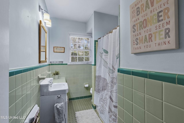 bathroom featuring tile walls, vanity, toilet, and walk in shower