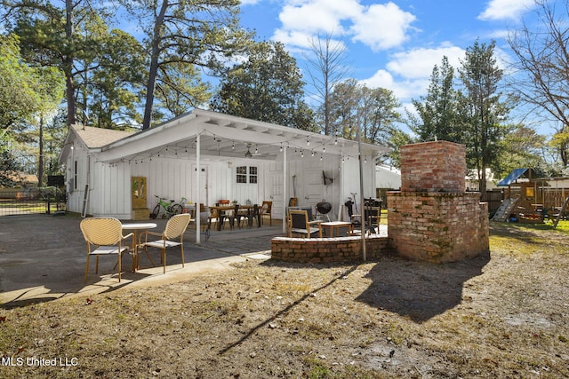 rear view of property featuring a patio area and a playground