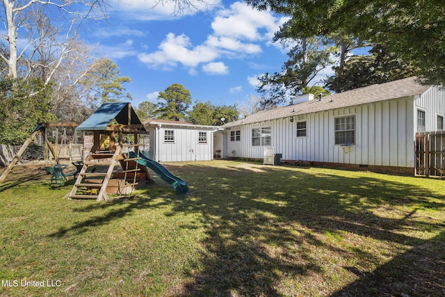 back of property featuring a lawn and a playground