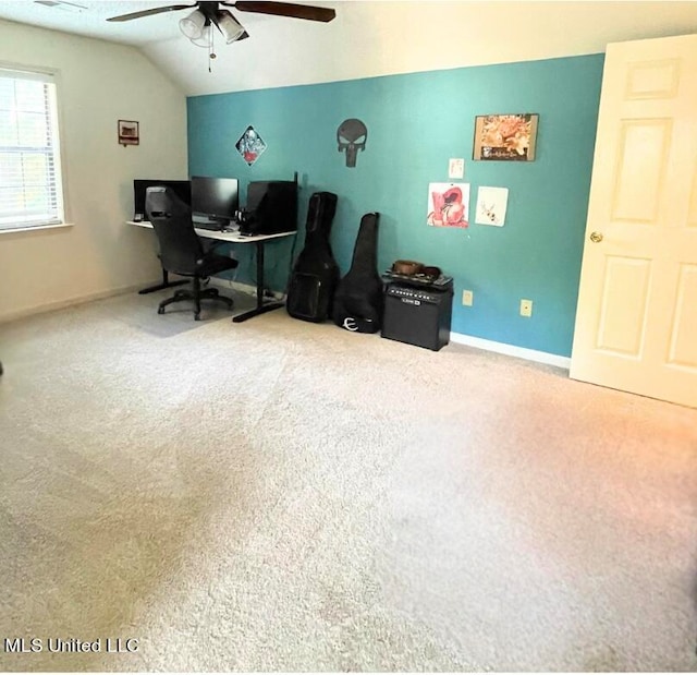 carpeted home office featuring lofted ceiling and ceiling fan