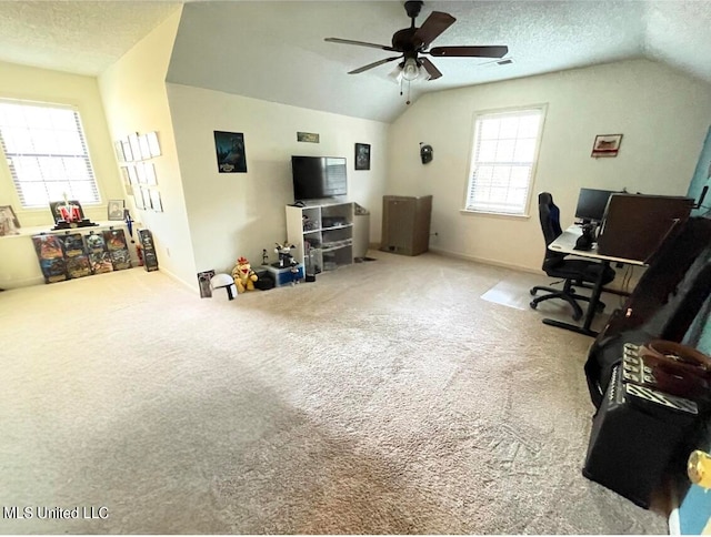 carpeted home office featuring ceiling fan, a textured ceiling, and vaulted ceiling