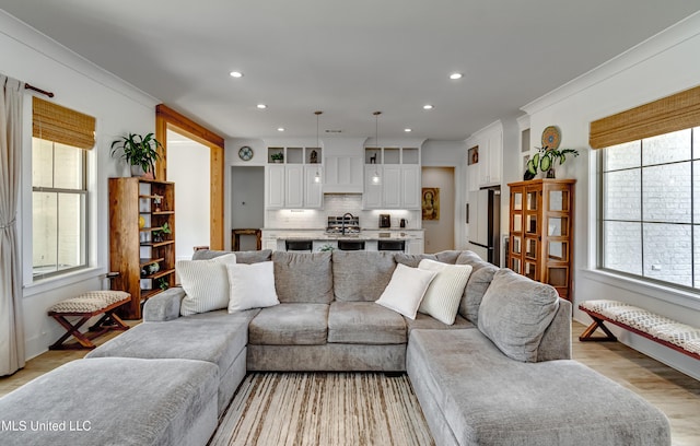 living area featuring ornamental molding, recessed lighting, and light wood-style flooring