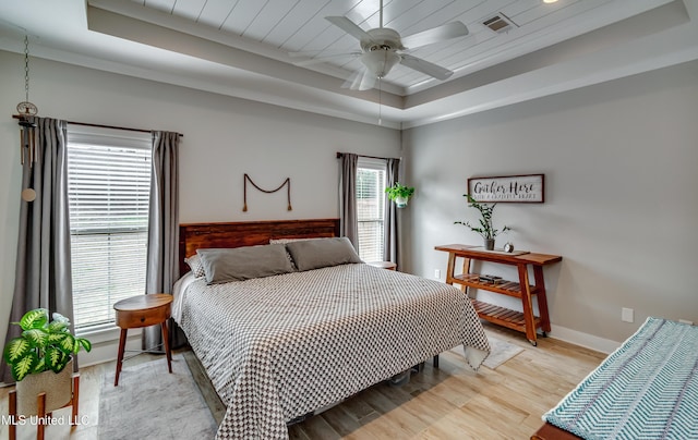 bedroom with wooden ceiling, light wood-style floors, baseboards, and a tray ceiling