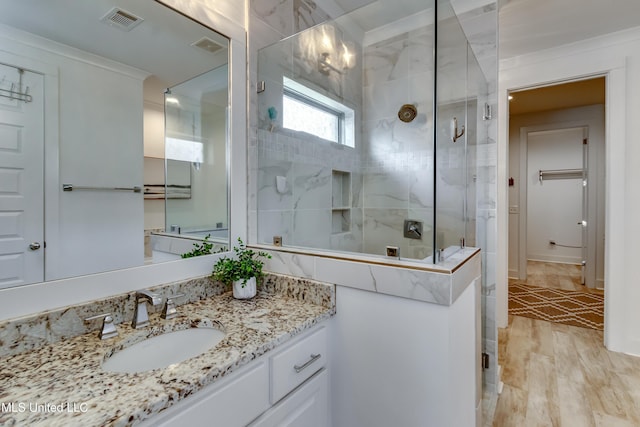 full bathroom featuring wood finished floors, vanity, visible vents, a spacious closet, and a shower stall