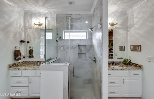 bathroom with a sink, two vanities, and a shower stall