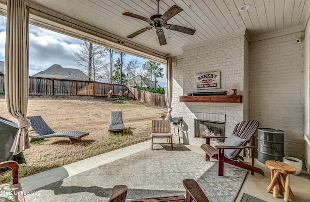 view of patio featuring a fenced backyard, a ceiling fan, and an outdoor brick fireplace