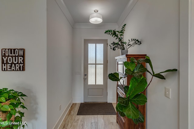 doorway to outside with light wood-style floors, ornamental molding, and baseboards