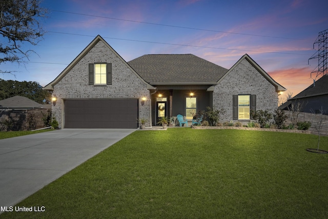 view of front of property featuring driveway, a front lawn, a shingled roof, and brick siding