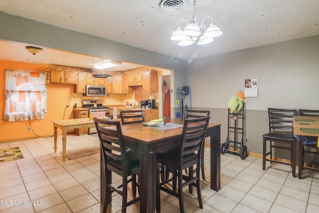 7041 Bosarge Rd, Long Beach, MS 39560 - dining space featuring light tile patterned flooring, a textured ceiling, and a chandelier