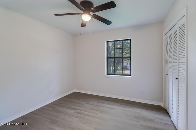 2550 Davidson Rd, Ocean Springs, MS 39564 - unfurnished bedroom featuring wood finished floors, a closet, baseboards, and ceiling fan