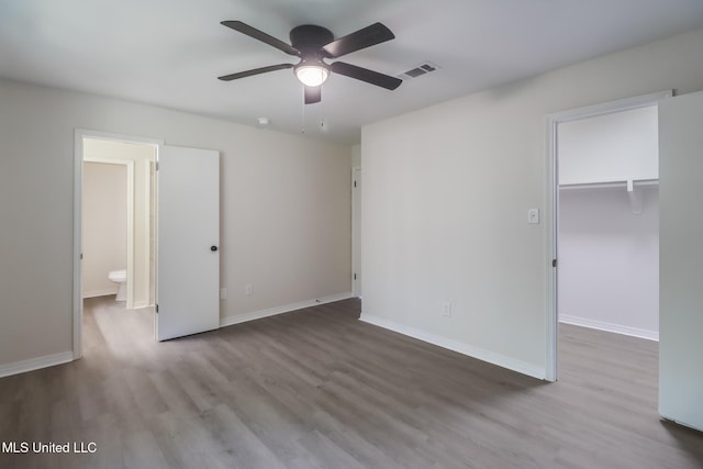 2550 Davidson Rd, Ocean Springs, MS 39564 - unfurnished bedroom with wood finished floors, a walk in closet, baseboards, and a closet