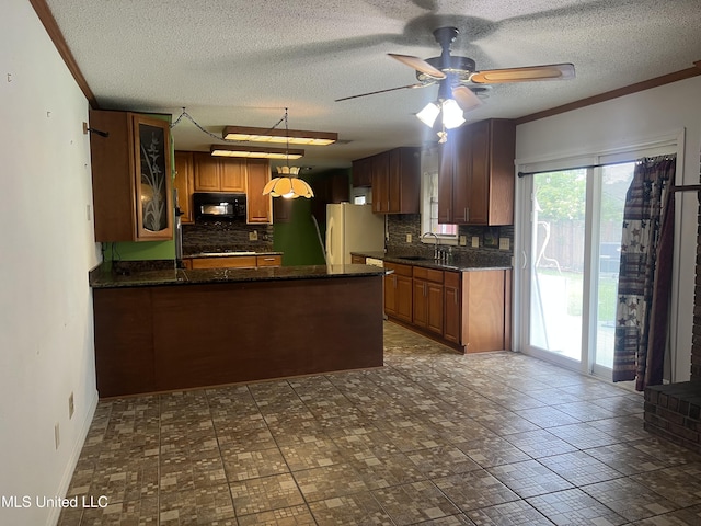 2285 Harkness Ct, Biloxi, MS 39532 - kitchen featuring black microwave, a peninsula, freestanding refrigerator, tasteful backsplash, and a textured ceiling