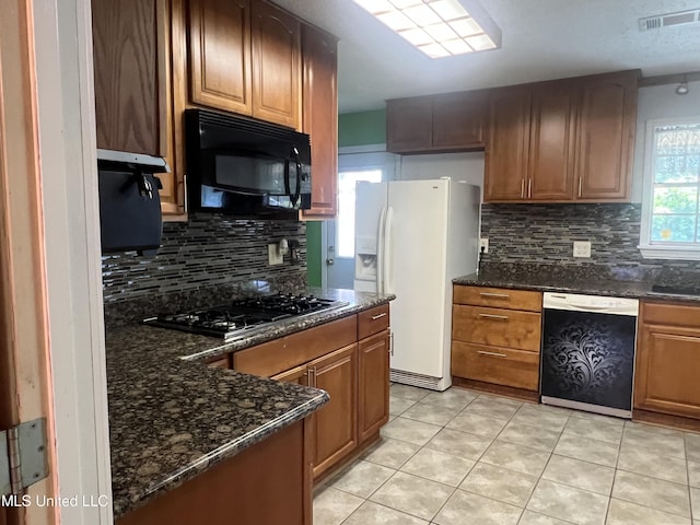 2285 Harkness Ct, Biloxi, MS 39532 - kitchen with black microwave, dishwasher, white fridge with ice dispenser, gas cooktop, and decorative backsplash