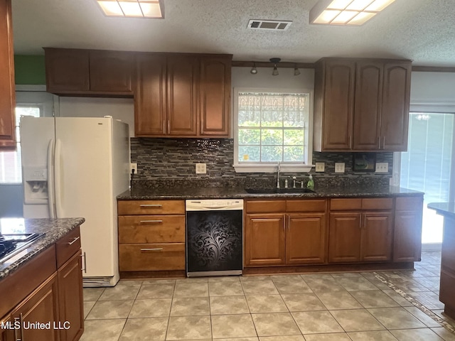 2285 Harkness Ct, Biloxi, MS 39532 - kitchen featuring white appliances, a sink, decorative backsplash, dark stone countertops, and a textured ceiling