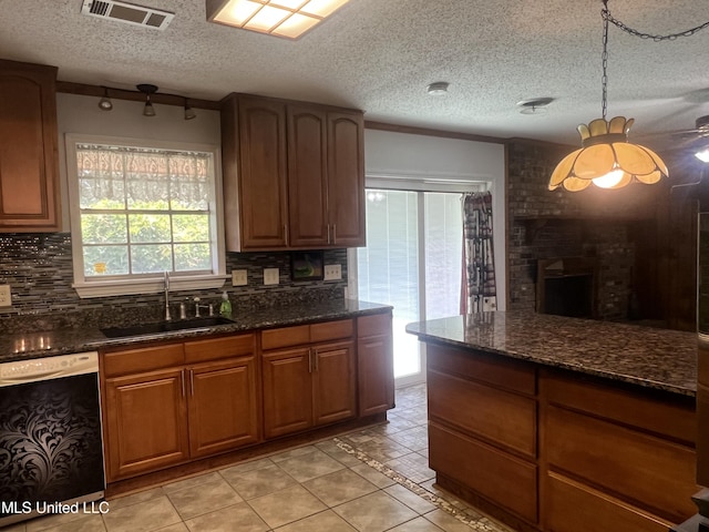 2285 Harkness Ct, Biloxi, MS 39532 - kitchen featuring dishwashing machine, a sink, a textured ceiling, tasteful backsplash, and dark stone counters