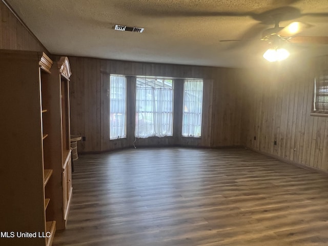 2285 Harkness Ct, Biloxi, MS 39532 - spare room with wood finished floors, a textured ceiling, ceiling fan, wooden walls, and baseboards