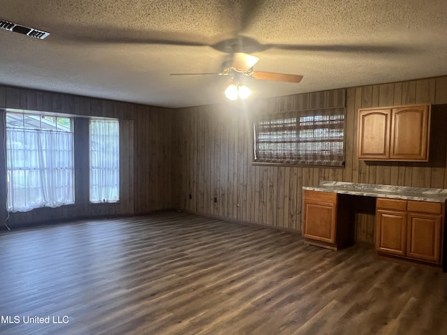 2285 Harkness Ct, Biloxi, MS 39532 - kitchen featuring dark wood-style flooring, a textured ceiling, brown cabinets, ceiling fan, and light countertops