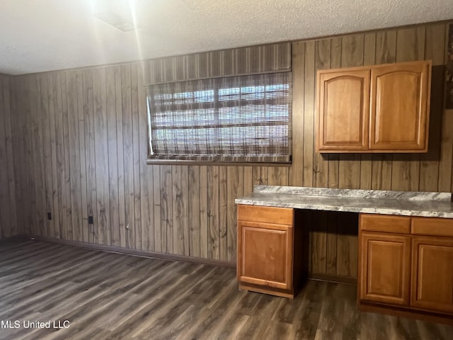 2285 Harkness Ct, Biloxi, MS 39532 - unfurnished office featuring built in study area, dark wood-type flooring, wood walls, baseboards, and a textured ceiling