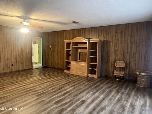 2285 Harkness Ct, Biloxi, MS 39532 - unfurnished living room featuring ceiling fan, a textured ceiling, dark wood-style floors, wood walls, and baseboards