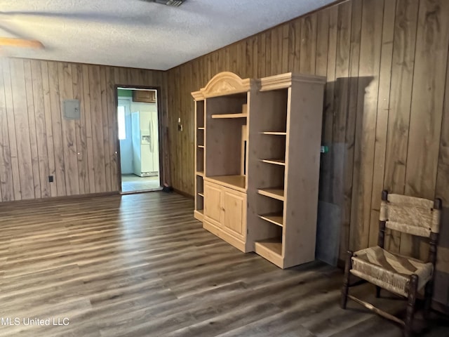 2285 Harkness Ct, Biloxi, MS 39532 - unfurnished bedroom featuring white refrigerator with ice dispenser, wooden walls, a textured ceiling, dark wood finished floors, and baseboards
