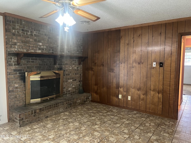 2285 Harkness Ct, Biloxi, MS 39532 - unfurnished living room featuring a textured ceiling, ceiling fan, wood walls, a fireplace, and baseboards