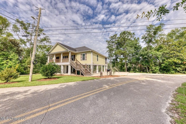 view of front of property featuring covered porch and a front yard