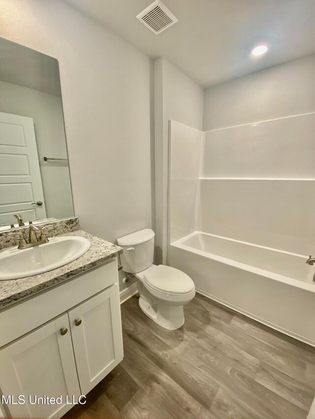 full bathroom with vanity,  shower combination, toilet, and wood-type flooring