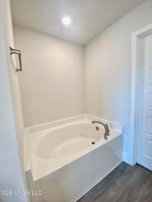 bathroom with wood-type flooring and a tub