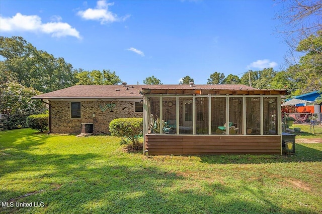 back of house featuring a yard, a sunroom, and central air condition unit