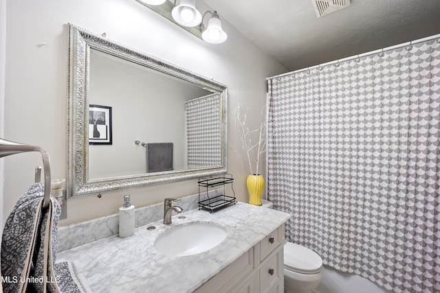 bathroom with vanity, curtained shower, and toilet