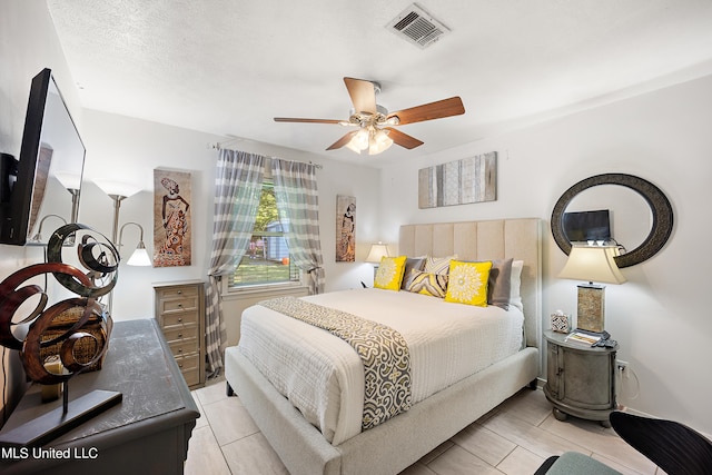 bedroom with ceiling fan and a textured ceiling