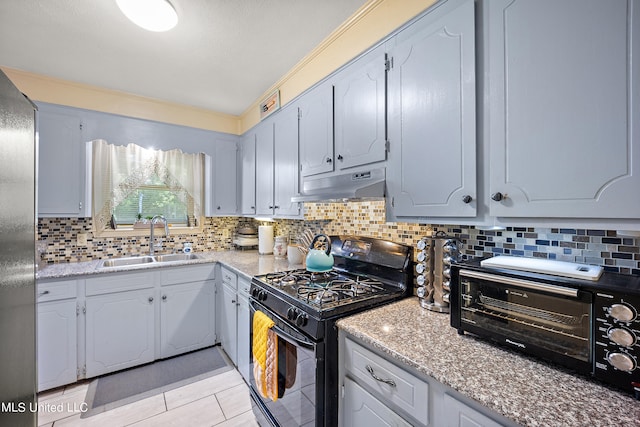 kitchen featuring backsplash, light tile patterned flooring, sink, and black gas stove