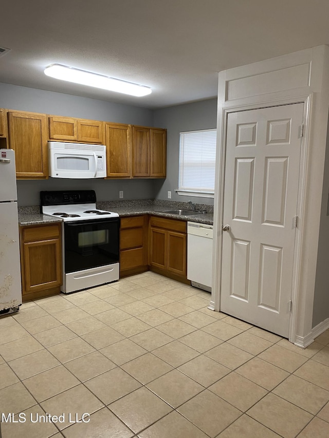 kitchen featuring light tile patterned floors and white appliances