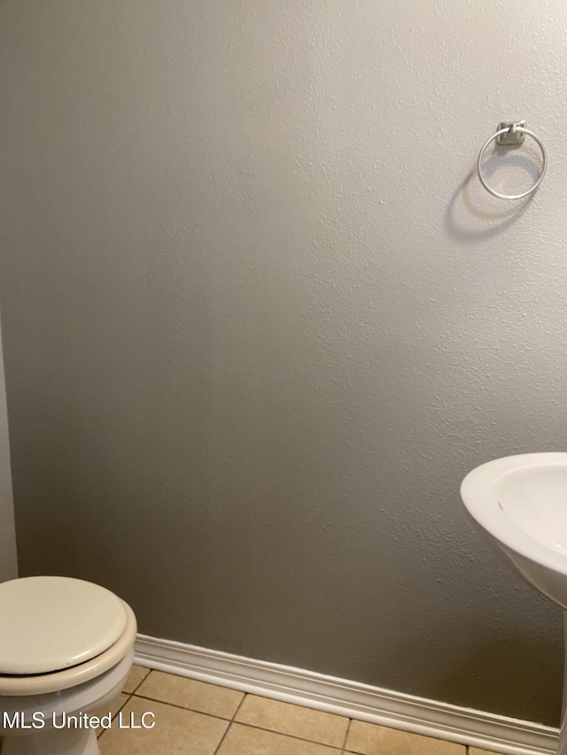 bathroom with toilet and tile patterned flooring