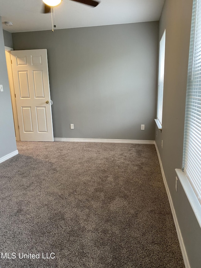 unfurnished room with ceiling fan and carpet