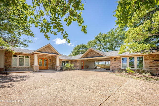 ranch-style house with french doors, brick siding, a shingled roof, driveway, and a carport