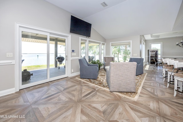 living area featuring baseboards, visible vents, and a healthy amount of sunlight