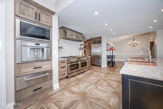 kitchen featuring built in appliances, baseboards, ventilation hood, a sink, and a warming drawer