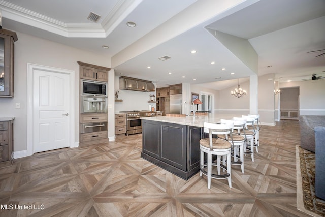 kitchen with ornamental molding, built in appliances, baseboards, ceiling fan with notable chandelier, and a warming drawer