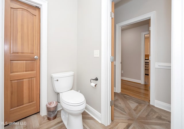 bathroom featuring baseboards and toilet